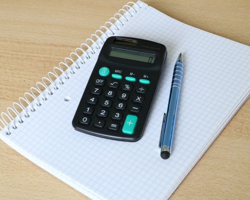 Калькулятор и ручка на тетради